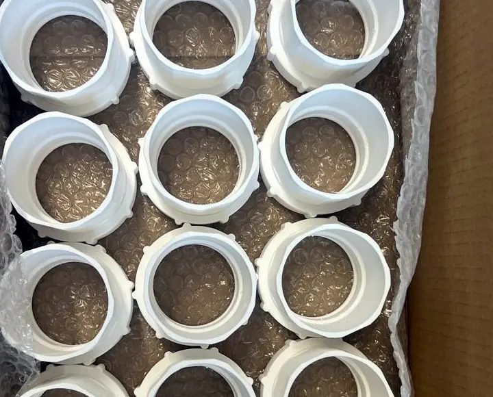 Detail of the box of 3D printed couplers with their nuts fitted, in bubble wrap