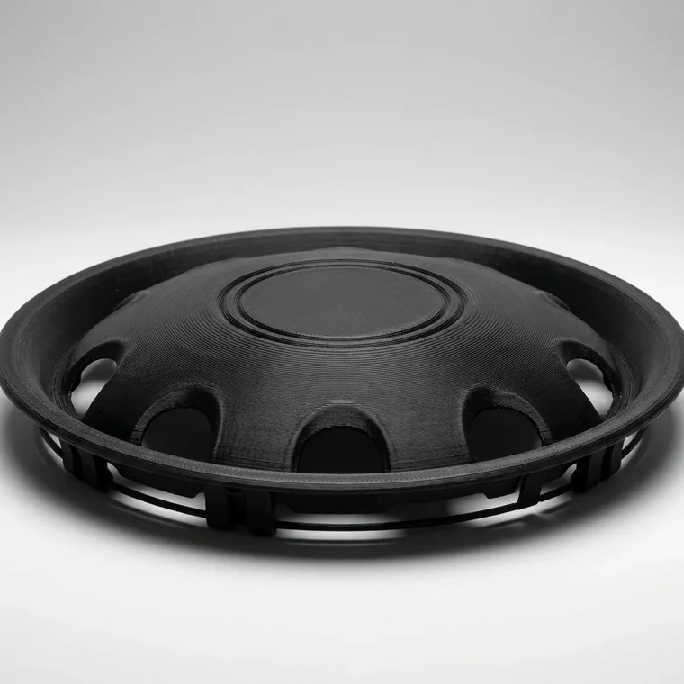 Matte-black 3D printed reproduction of the wheel centre cap with visible print layers