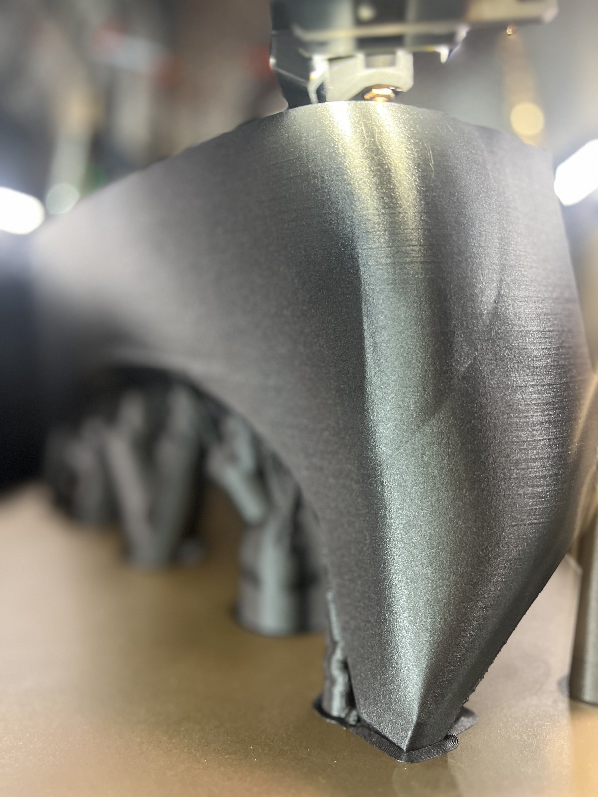 Macro photo of an FDM part mid-print showing individual deposited layer lines