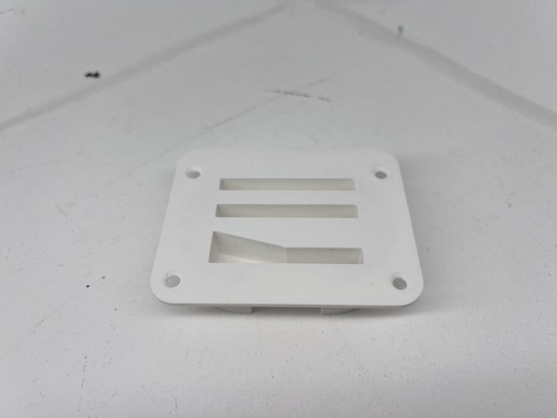 A reverse-engineered machine-guard bracket reproduced in carbon-fibre nylon next to its worn original