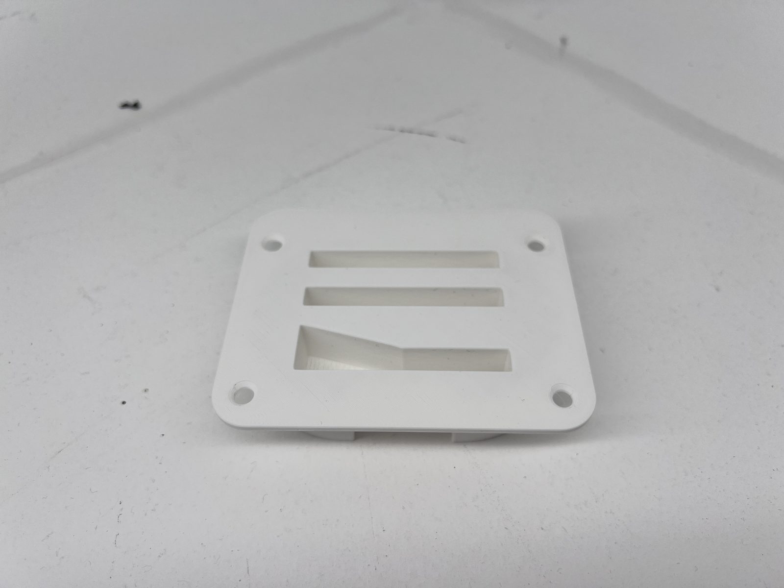 Broken OEM machine guard bracket beside its 3D-printed PA12-CF reproduction