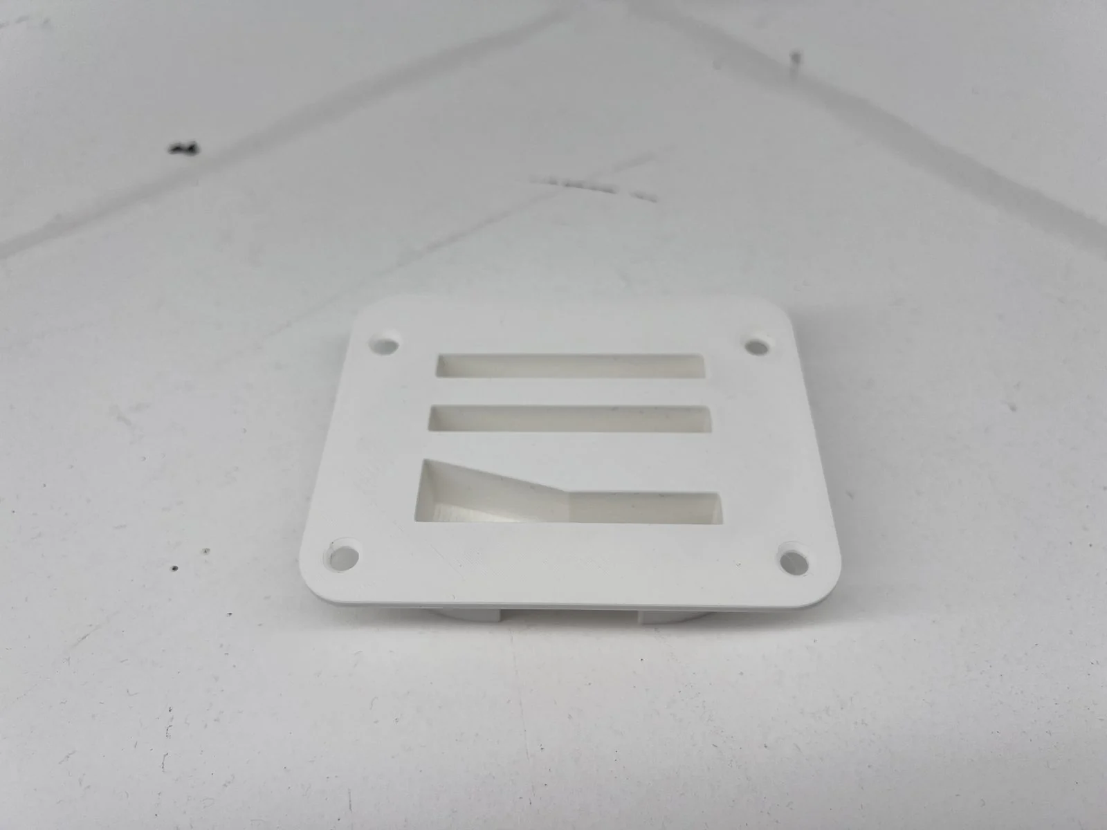 Broken OEM machine guard bracket beside its 3D-printed PA12-CF reproduction