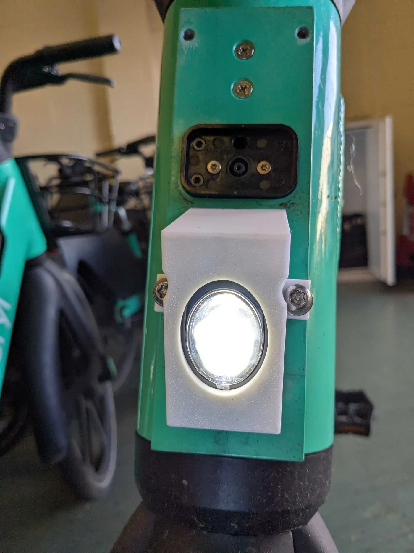 The finished mount fitted to a Beryl e-bike head stem, LED lit, showing the fit and angle on the bike