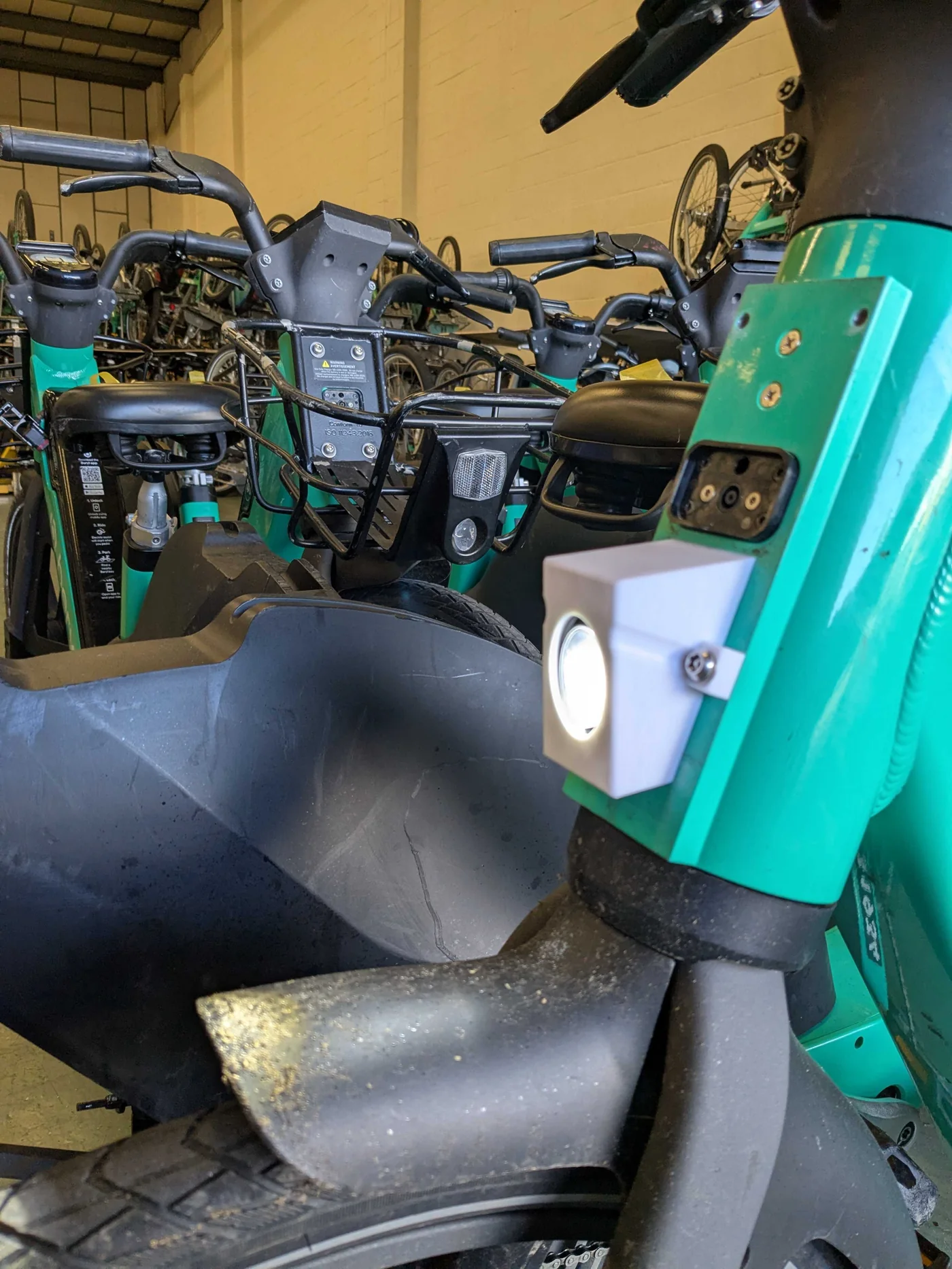 A Beryl e-bike with the front-light mount fitted to the head stem, in the depot