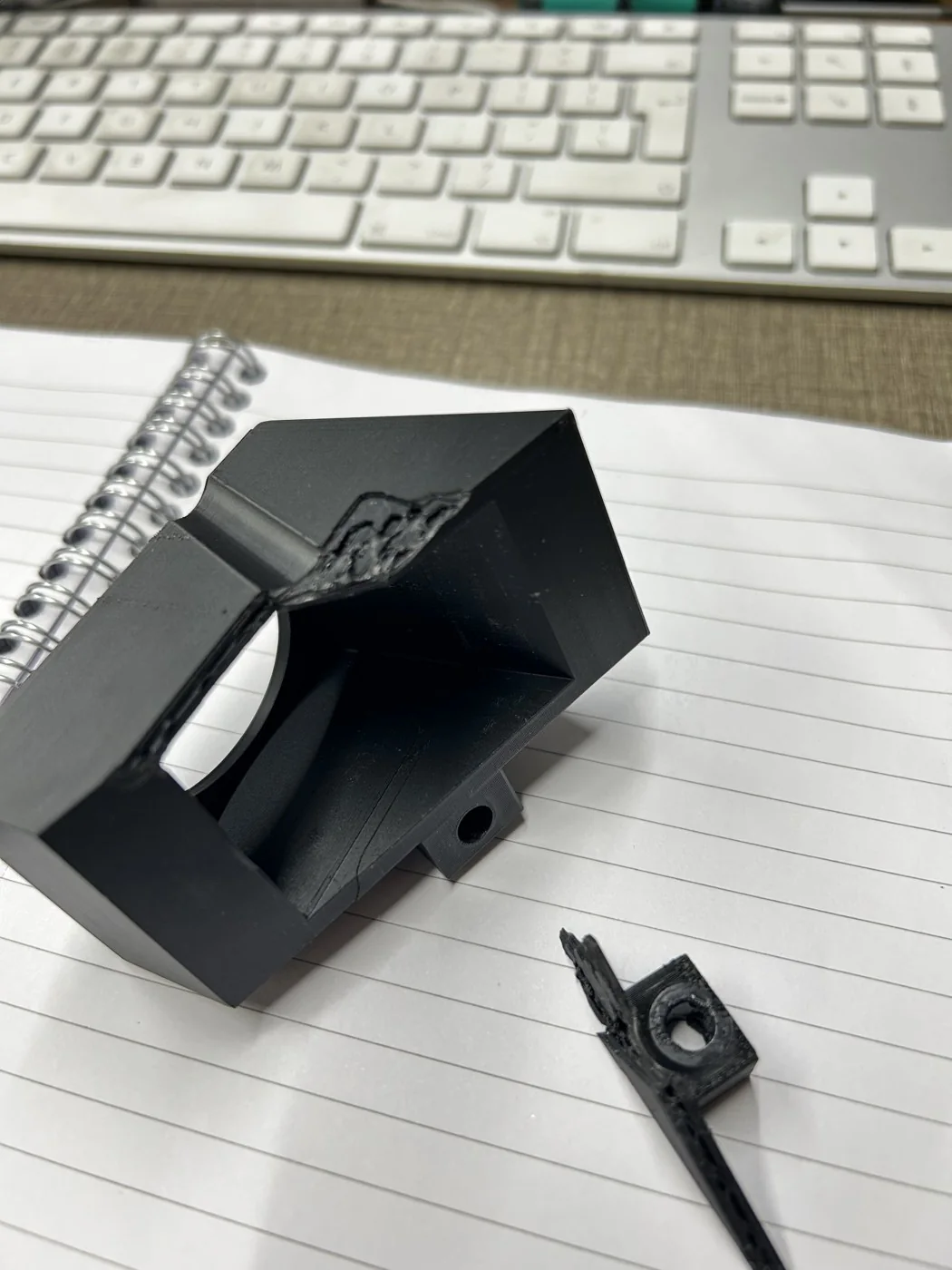 Top-down view of the final PET-GF mount on the bench, showing the internal light funnel and the companion clip printed alongside it