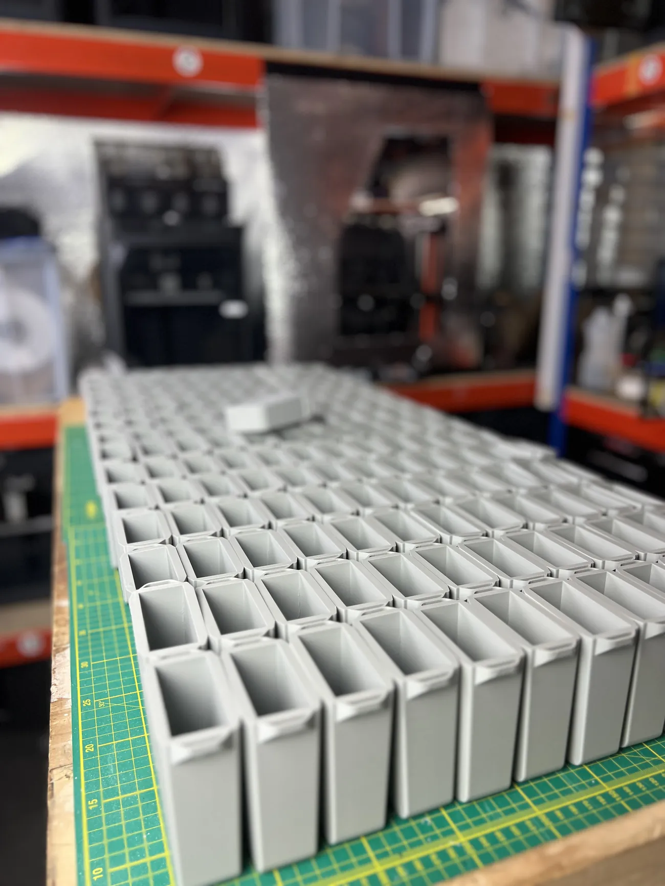 Rows of grey 3D printed DURABIN bodies laid out across the workbench at the 3D Printing Express workshop in Poole