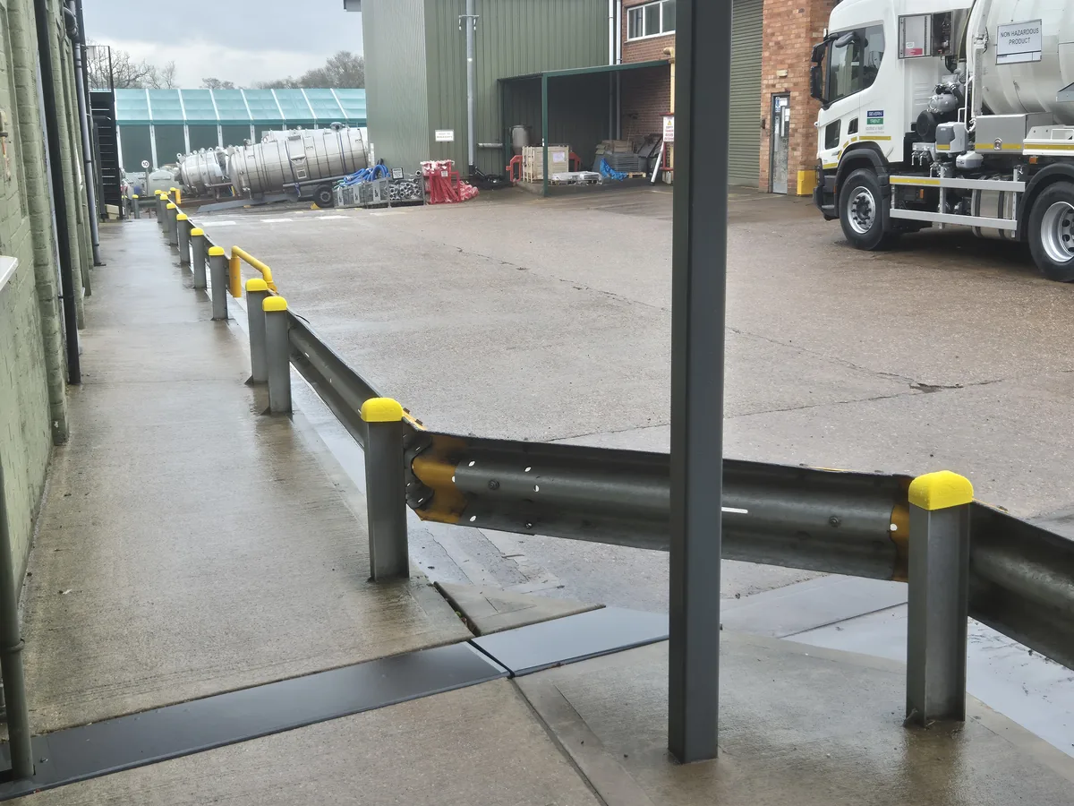Armco safety barriers with yellow 3D-printed end caps around the Whale Tankers yard, vacuum tanker in the background