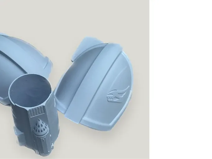 Raw 3D-printed light-grey armour panels showing print lines and panel-split character before bonding and finishing