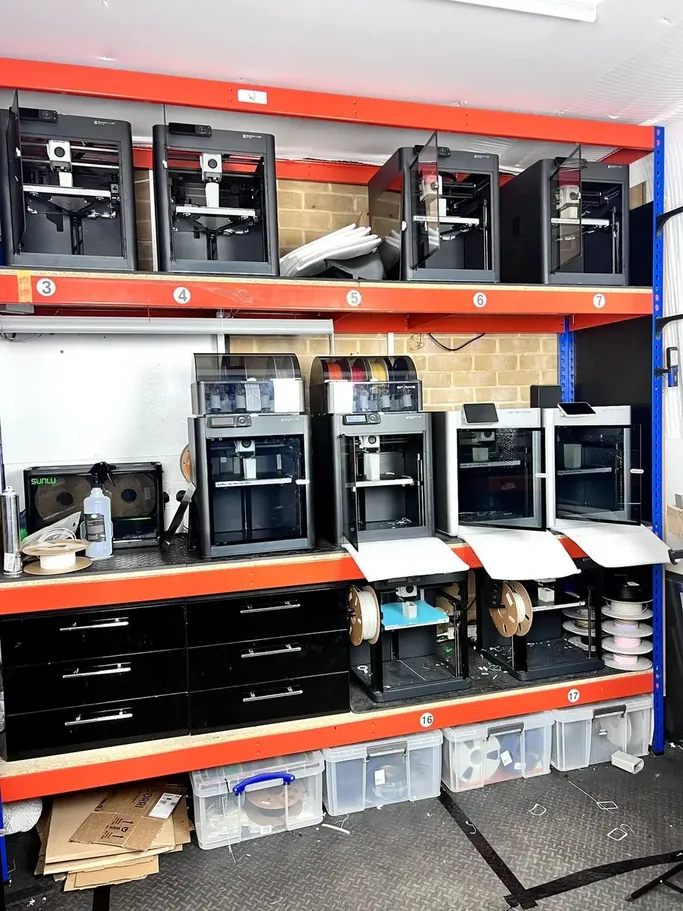 3DPE print farm interior with multiple Bambu Lab printers running in parallel on industrial shelving