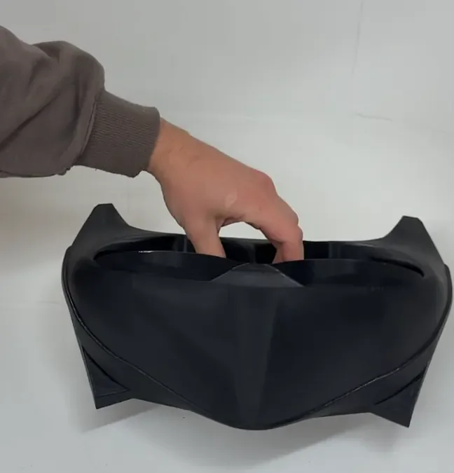 Black 3D-printed sculptural fashion piece made for Chopova Lowena, held up in the studio