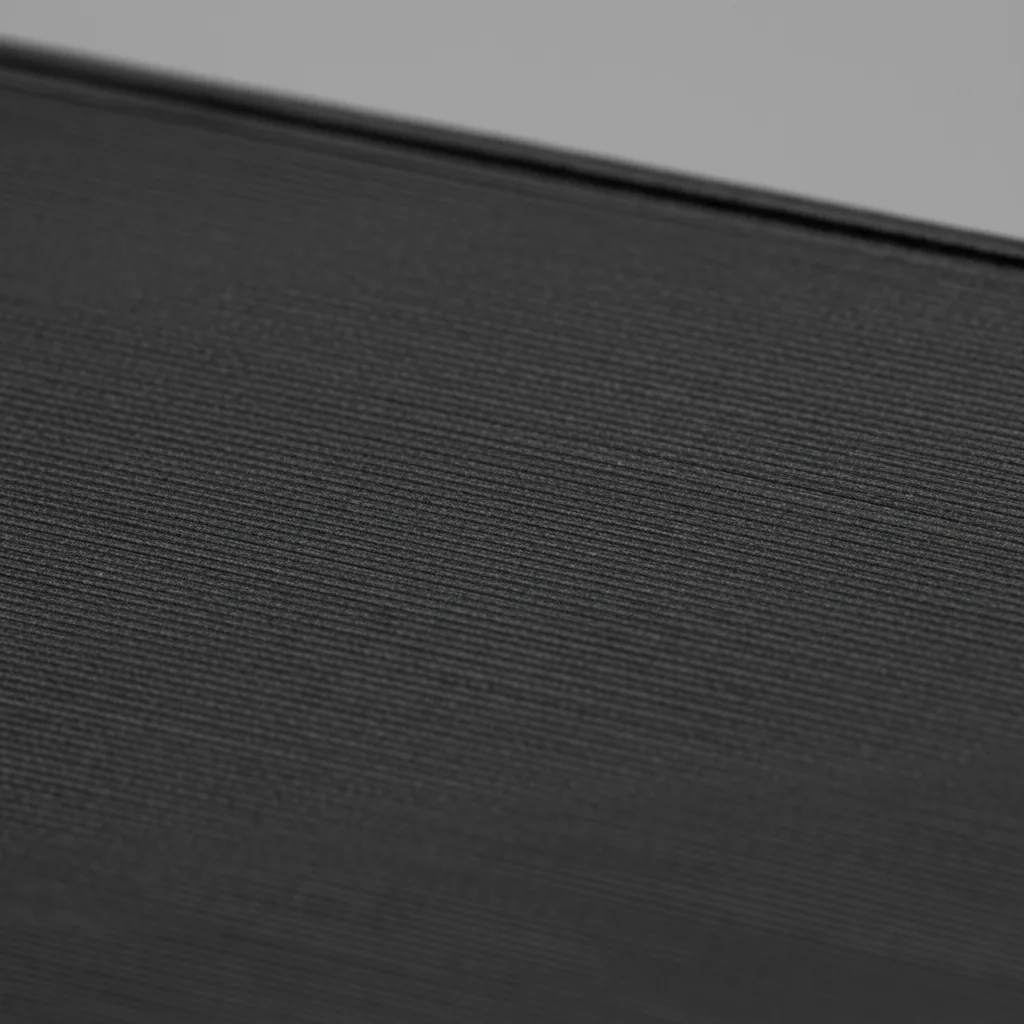 Extreme macro of the surface of a matte dark grey 3D-printed PA6-CF part showing speckled chopped carbon-fibre flecks and fine layer lines
