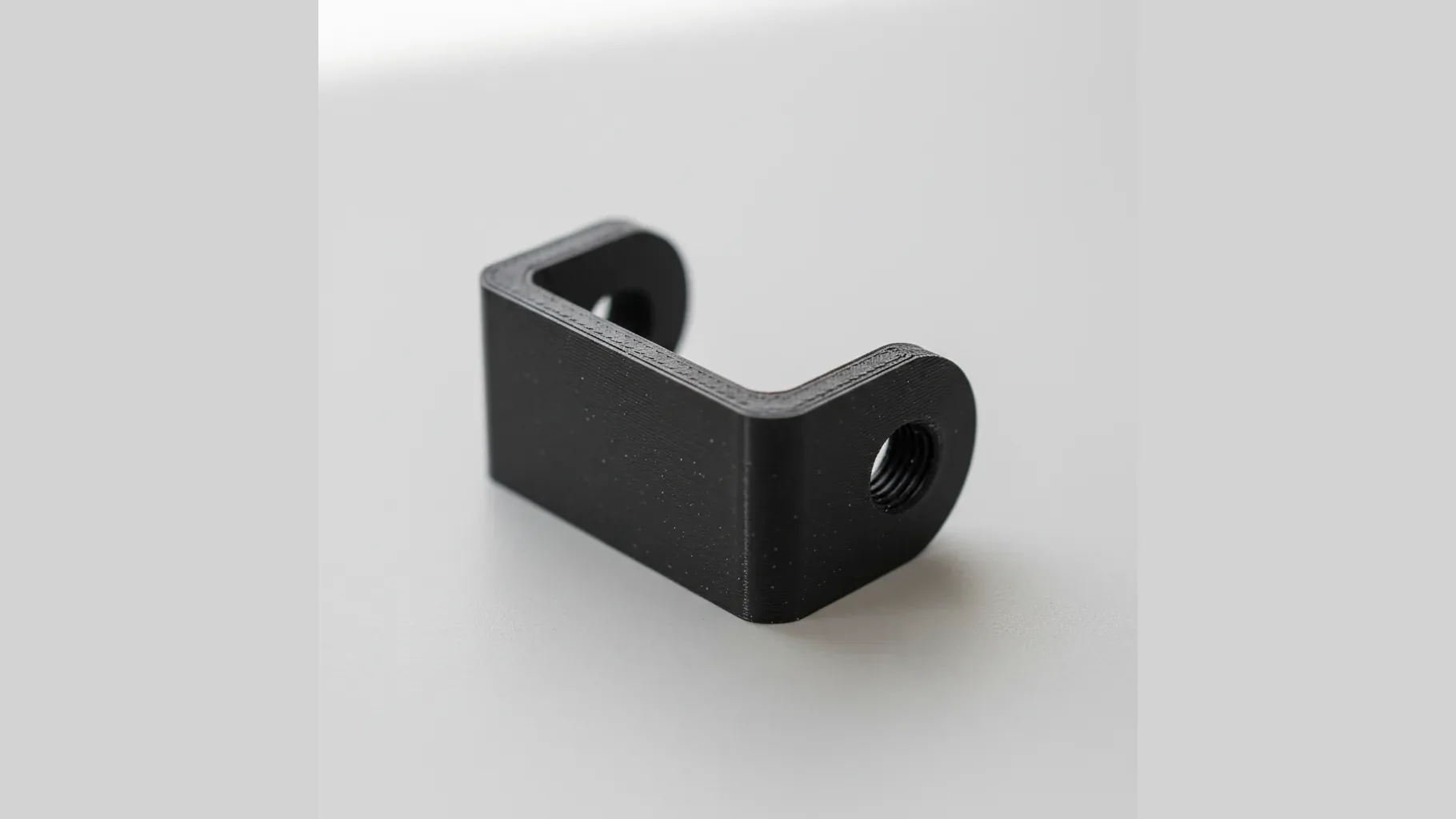 A single 3D-printed PET-CF structural bracket with precise bolt holes