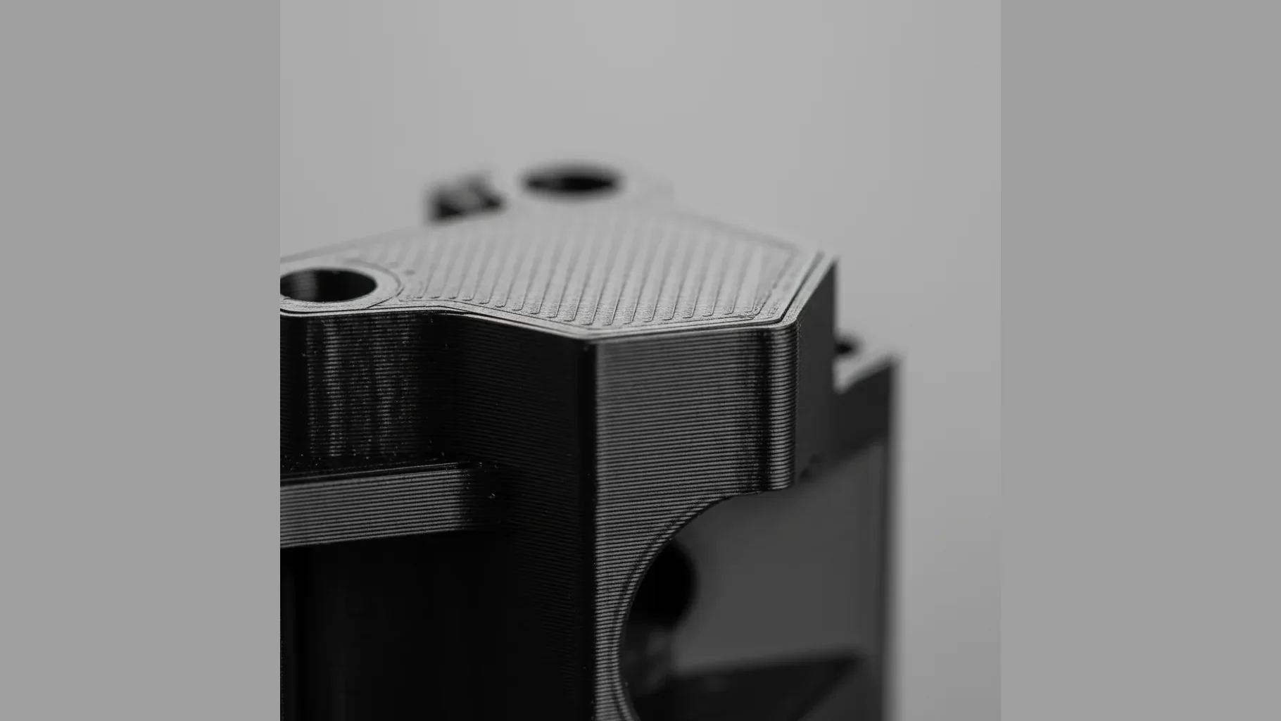 Extreme macro of a 3D-printed black PETG-ESD part surface showing fine layer lines and a uniform semi-matte black finish