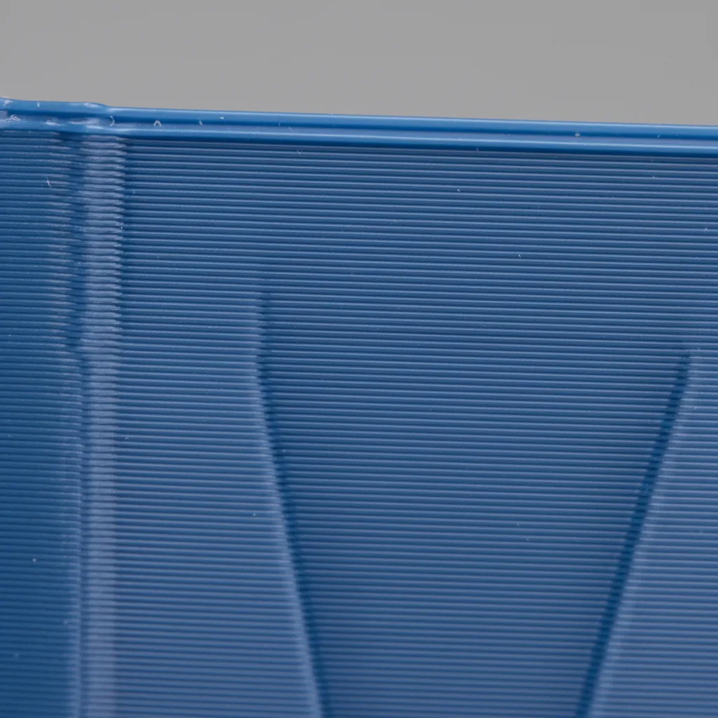 Extreme macro of a 3D-printed PLA+ part surface showing clean even layer lines and a satin opaque finish