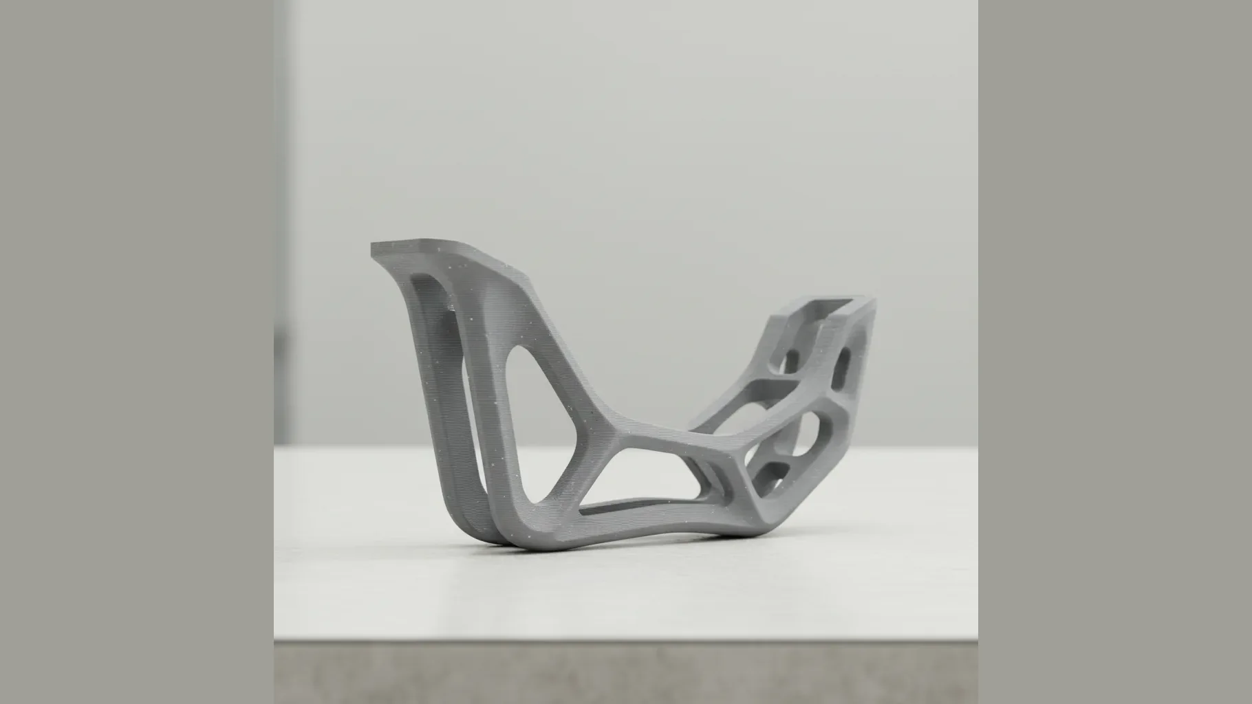 A 3D-printed grey PPS-GF topology-optimised lightweight bracket with stress-led ribbing